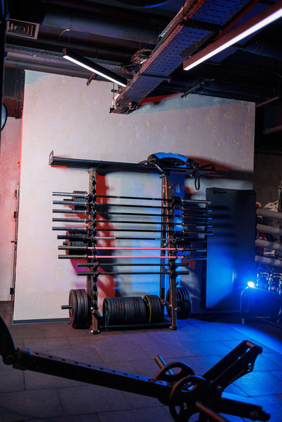 Rack in the gym with metal barbells for exercise. Squat bar with weight. Gym equipment - Foto, afbeelding