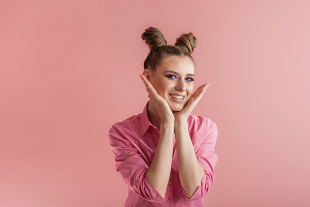 Funny girls with pigtails in pink shirt on pink background. Two bun hairstyle. Concept of naivety - Photo, Image