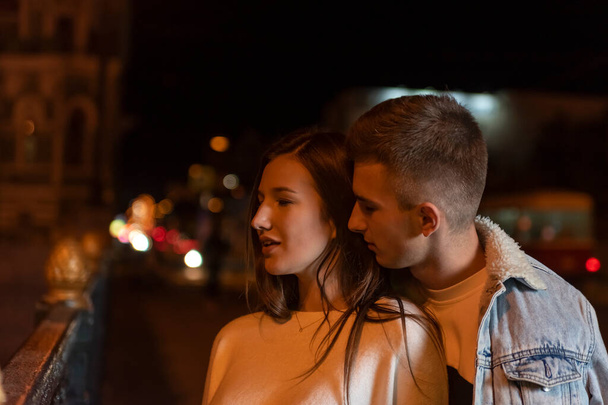 Hermosa pareja joven se para en la calle por la noche. Fecha romántica - Foto, imagen