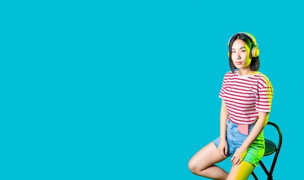 Young asiatic woman wearing wireless headphones listening music serious confident - copyspace banner - Foto, immagini