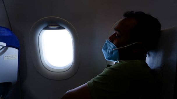 Kolkata,India, 13.03.2022. Male passenger falls asleep into the plane due to fatigue while traveling by flight or plane. - Photo, Image