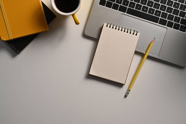 Not defteri, kalem, dizüstü bilgisayar ve kahve fincanı olan üst görünüm beyaz ofis masası.. - Fotoğraf, Görsel