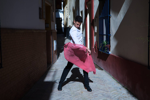 flamenco ja mustalainen mies, pukeutuneena mustavalkoiseen paitaan tanssimassa pilkullinen nenäliina kädessään kujalla Välimeren kaupungin kaduilla. Ihmiskunnan flamenco-kulttuuriperintö - Valokuva, kuva