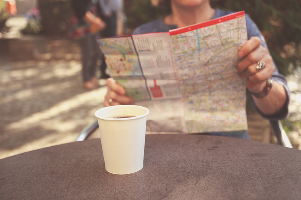 Mujer mayor estudiando mapa y tomando café
 - Foto, Imagen