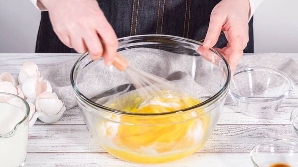 Step by step. Mixing ingredients in a large glass mixing bowl to prepare French toast. - Фото, зображення