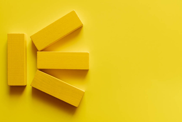 top view of bright colored blocks on yellow background - Foto, afbeelding