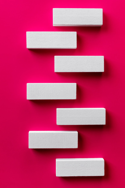 top view of white tetragonal blocks on bright pink background - Фото, зображення