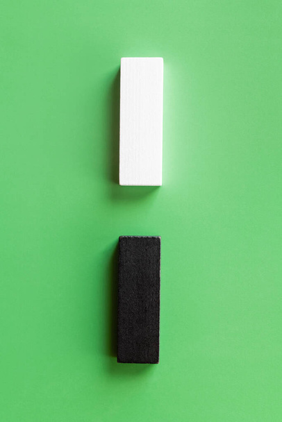 top view of vertical line of white and black blocks on green background - Foto, Bild