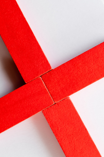 крупным планом крест из красных блоков на белом фоне, вид сверху - Фото, изображение