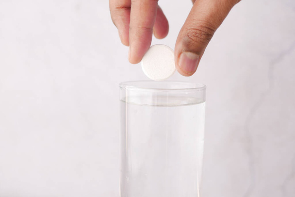 Comprimidos solúveis efervescentes e vidro de água sobre fundo roxo  - Foto, Imagem