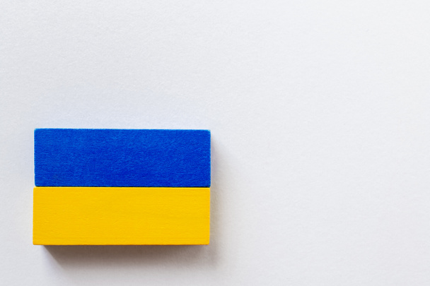 vista superior de bloques azules y amarillos sobre fondo blanco, concepto ucraniano - Foto, Imagen