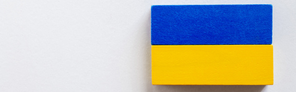 vista superior de bloques tetragonales azules y amarillos sobre fondo blanco, concepto ucraniano, bandera - Foto, imagen