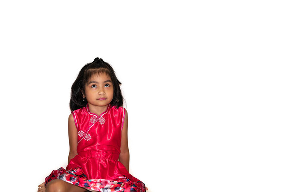 Adorable asiática niña sentada en el fondo blanco mirando hacia arriba - Foto, imagen