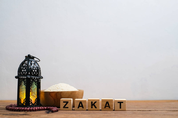 Святий Коран і рисове зерно в дерев'яній мисці в мішку на дерев'яному столі, Ісламський Закат концепції. - Фото, зображення