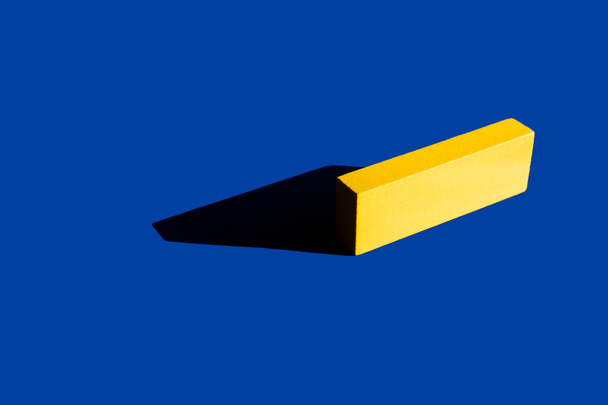 ярко-желтый тетрагональный блок на синем фоне с тенью, украинская концепция - Фото, изображение