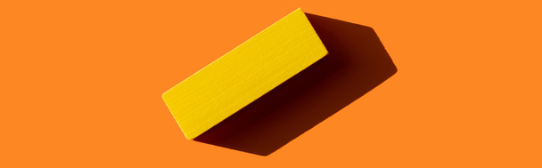 vista superior del bloque rectangular amarillo sobre fondo naranja con sombra, banner - Foto, imagen