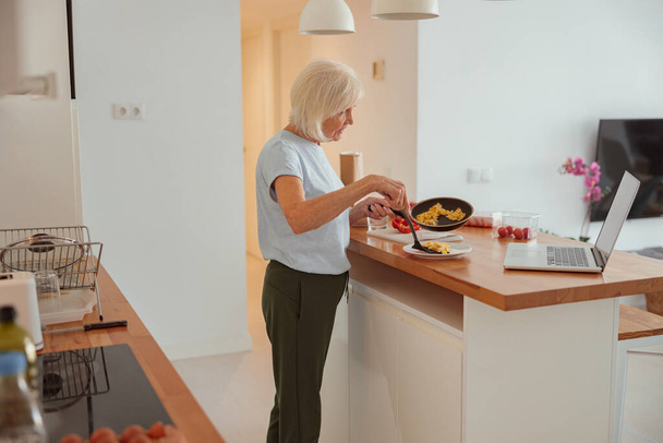 Ηλικιωμένη γυναίκα τρώει υγιεινό πρωινό στο σπίτι - Φωτογραφία, εικόνα