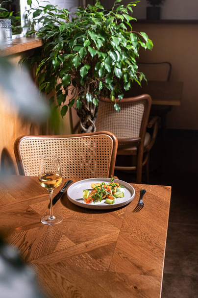 Köstliche Pfannkuchen mit rotem Fisch (Lachs, Forelle), Rucola und Sahnesoße auf einem rustikalen Tisch in einem stilvollen italienischen Restaurant mit Weidenleinen und natürlichen Blumen. - Foto, Bild