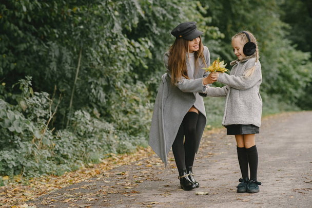 Cute and stylish family in a autumn park - Φωτογραφία, εικόνα