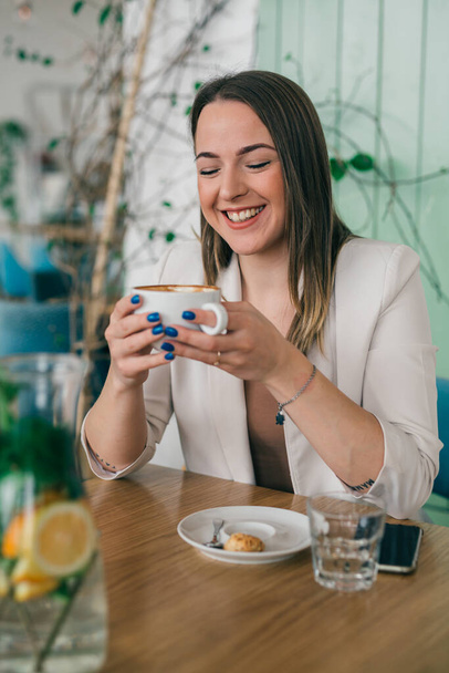 woman holding cup of coffee in cafe - Photo, image