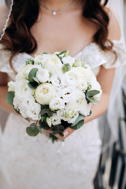 Elegant white bouquet of roses in the hands of the bride. Gift for the bride - Fotó, kép