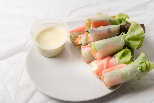 Свежий овощной салат рулон в трубке с лапшой на блюде изолированы на белом фоне азиатской уличной еды - Фото, изображение