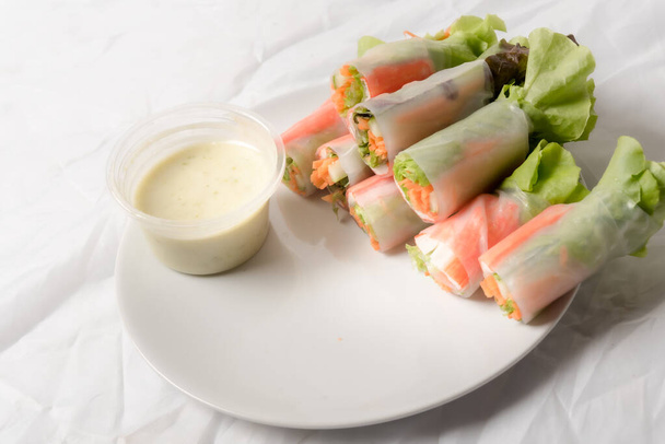 Свежий овощной салат рулон в трубке с лапшой на блюде изолированы на белом фоне азиатской уличной еды - Фото, изображение