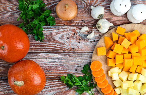 Seasonal vegetables for making pumpkin soup on wooden background. Top view. Copy space. - Фото, зображення