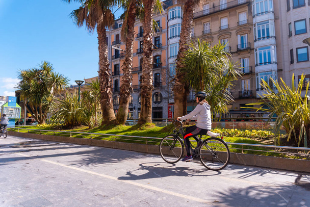 An adult woman walking on a bicycle a spring morning by the city - Foto, Imagem