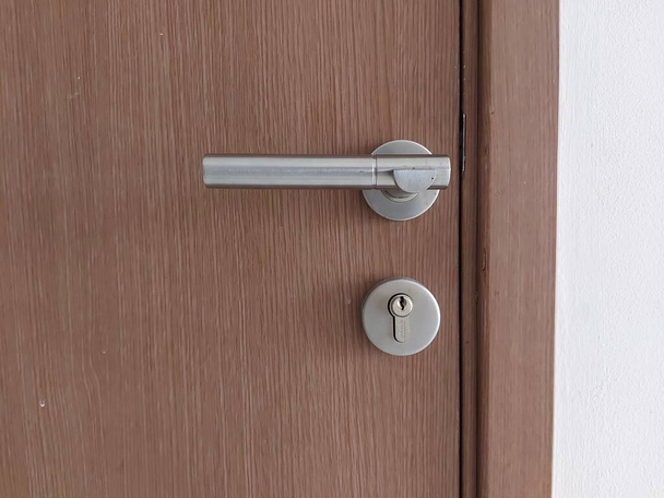 manija de la puerta con el agujero de la llave en madera. fondo aislado. espacio de copia - Foto, imagen
