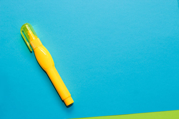 Желтый бумажный корректор на фоне разноцветной картонной бумаги. - Фото, изображение