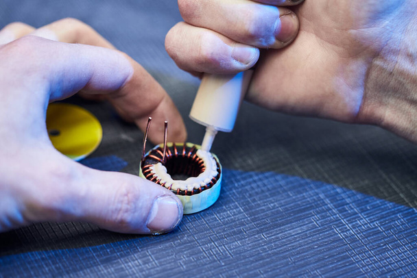 The master specialist makes electromagnetic coils for computer devices - Foto, afbeelding