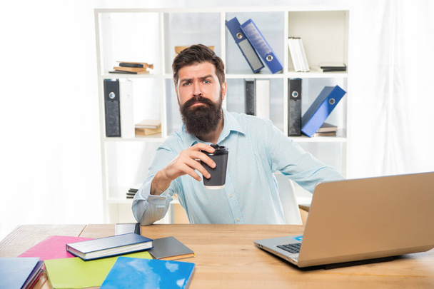 Fáradt profi férfi iszik elvitelre kávét ül az irodában, kávészünet - Fotó, kép