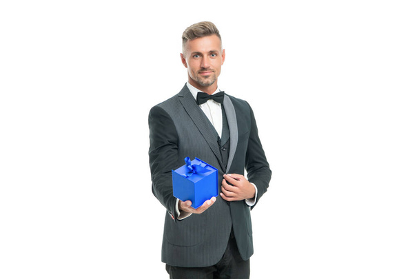 cheerful man in tuxedo and bow tie hold present box isolated on white background - 写真・画像