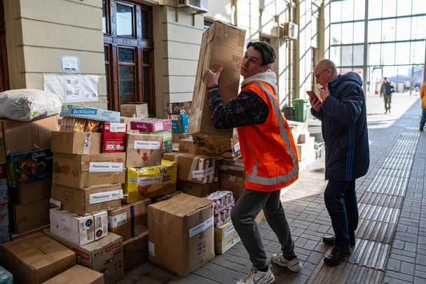 LVIV, UKRAINE - March 14, 2022: Humanitarian crisis during the war in Ukraine. Volunteers helping to feed thousands of refugees flee war-torn territories to Europe at Lviv Railway Station. - Foto, immagini