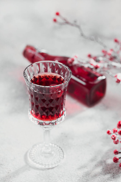 Homemade infused vodka, tincture or liqueur of red cherry on white background. Berry alcoholic drinks concept. - Foto, afbeelding
