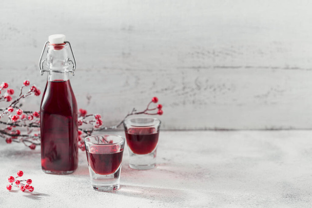 Homemade infused vodka, tincture or liqueur of red cherry on white background. Berry alcoholic drinks concept. - Foto, Imagen