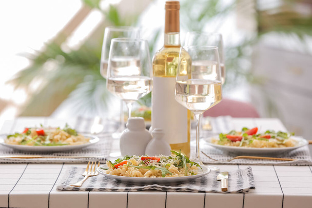Schöne Tischdekoration mit leckeren Nudeln und Weißwein - Foto, Bild