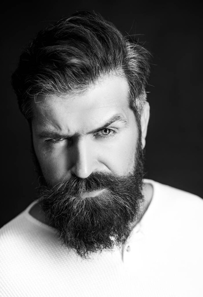 Крупный план бородатого человека на черном фоне - профессиональный студийный свет. Портрет взрослого человека кавказского внешнего вида изолирован на черном фоне
. - Фото, изображение
