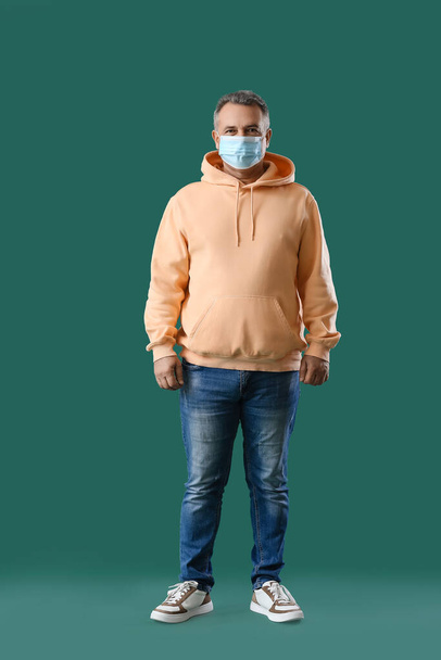 シニア男で医療マスク上の緑の背景 - 写真・画像