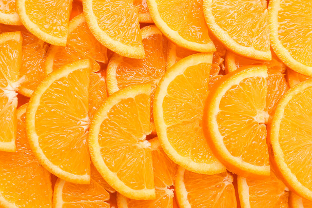 Muchas rodajas de naranja maduras como fondo, primer plano - Foto, imagen