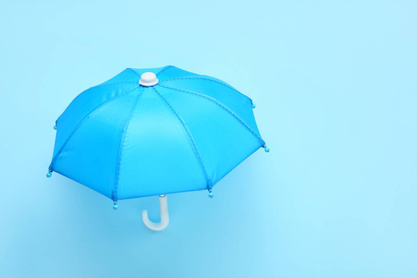 Open umbrella on blue background - Foto, imagen