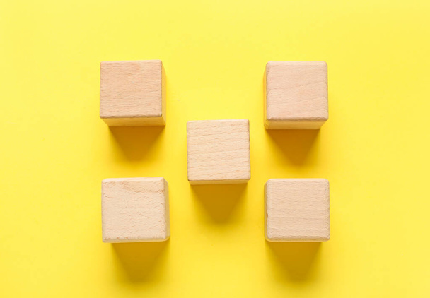 Wooden cubes on yellow background - Фото, изображение