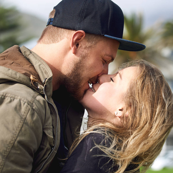 Ihr Leben ist voller Küsse. Aufnahme eines liebevollen jungen Paares, das Zeit miteinander im Freien verbringt. - Foto, Bild