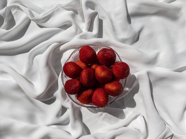 Rote Erdbeeren liegen auf einem weißen Laken. - Foto, Bild