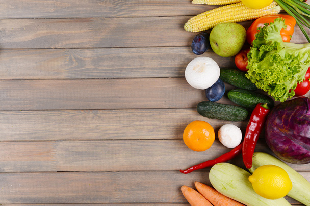 Fresh organic fruits and vegetables on wooden background - Fotó, kép