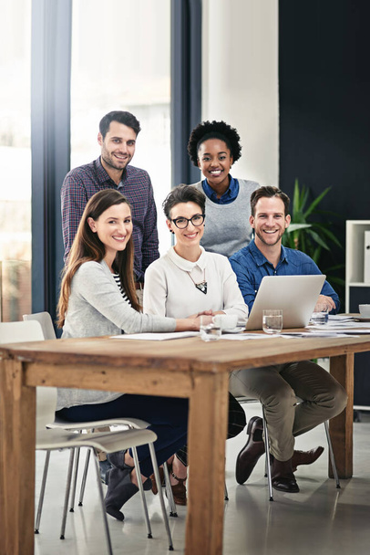 Erre a csapatra van szükséged. Egy csapat üzletember teljes hosszúságú portréja gyűlt össze egy laptop körül az irodában.. - Fotó, kép