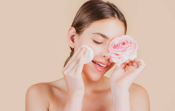 Beauty woman face with natural make up, rose flowers and with cotton pads, sponge, cotton ball. Beautiful female wellness cosmetics. Spa and wellness, skin care concept. Facial treatment. - Photo, Image