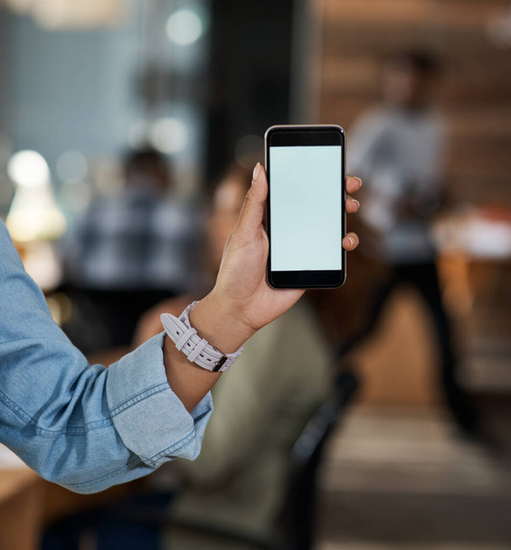 There are many connections to help boost your business. Closeup shot of an unrecognizable businesswoman holding up a cellphone with a blank screen in an office. - Foto, imagen
