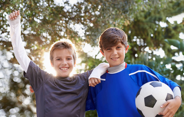 Boys will be boys. Shot of two young boys standing outside with a soccer ball. - Foto, Bild